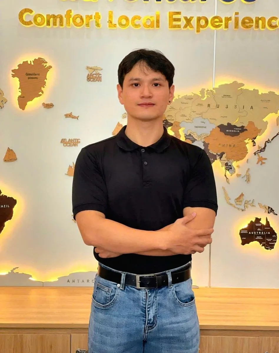 Fin (Fingo), local Hoi An private tour guide, standing confidently in front of a world map.